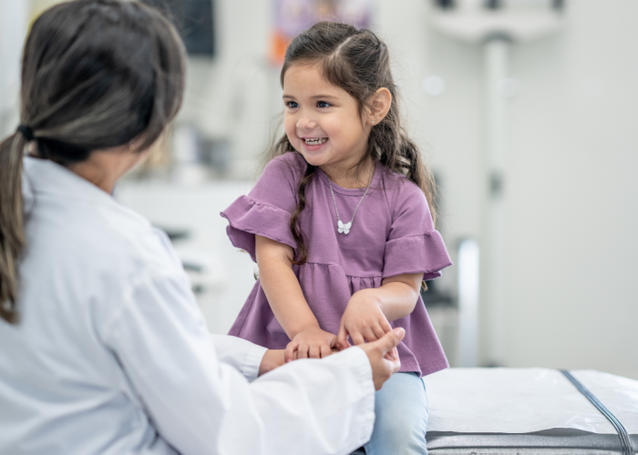 Ärztin sitzt Mädchen gegenüber